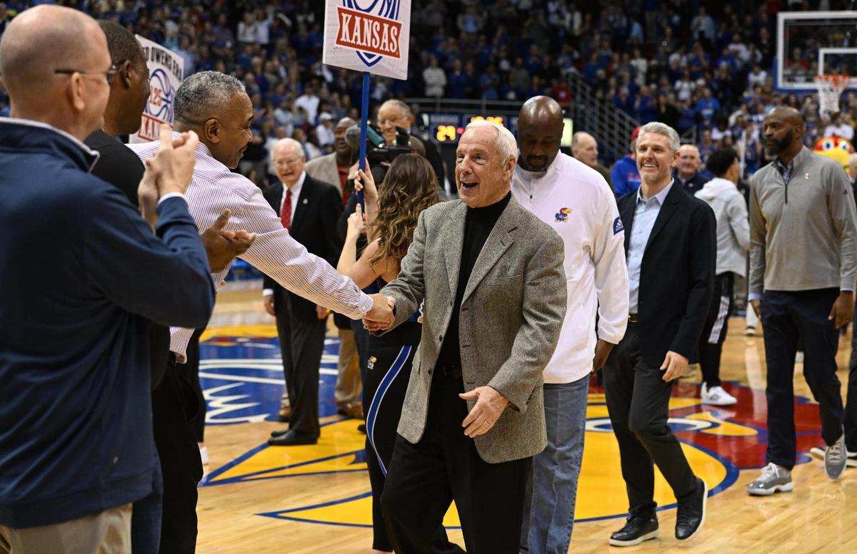 Former KU coach Roy Williams (middle) is greeted by former players and staff during halftime ceremonies on Jan. 14, 2023, at Allen Fieldhouse. KU was celebrating 125 years in college basketball.