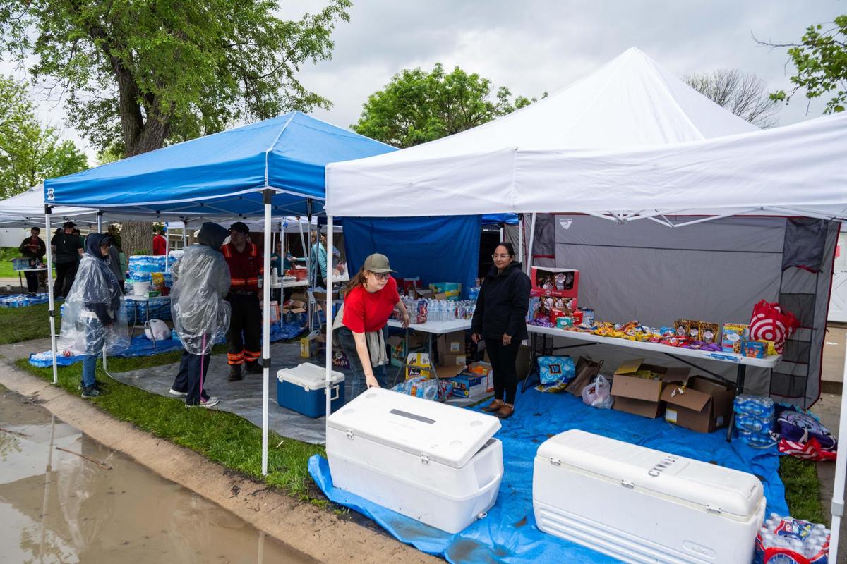 Volunteers set up tents with water, food, and supplies at Aspen Place Apartments in Gardner on Wednesday, May 7, 2025.