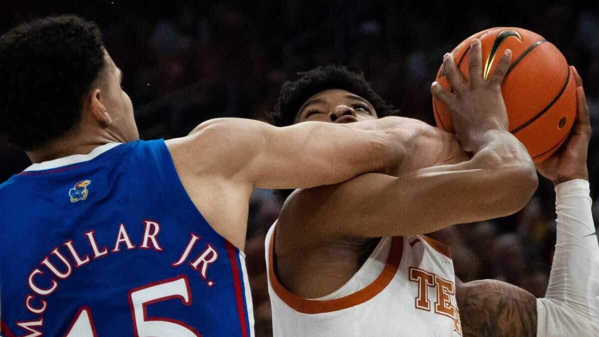 Texas Longhorns guard Tyrese Hunter gets an arm to the face from Kansas Jayhawks guard Kevin McCullar Jr. as he goes to shoot during the first half of the Longhorns’ game against the Jayhawks at the Moody Center in Austin, Saturday, March 4, 2023.