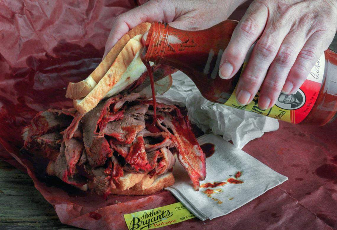 Before it is attacked, a tall pile of brisket at Arthur Bryant’s Barbecue in Kansas City gets topped off with some more sauce. 