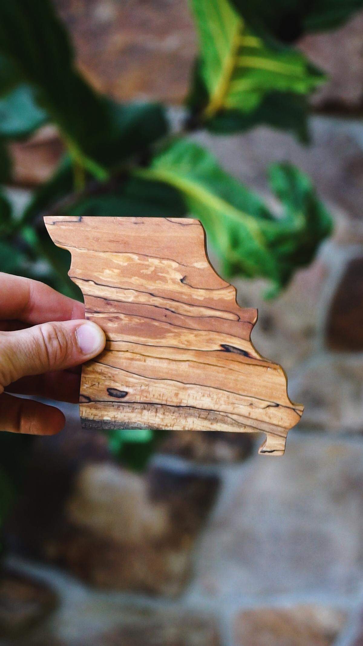 Justin Davies holds a state map he carved from wood from the flowering dogwood, Missouri’s state tree.