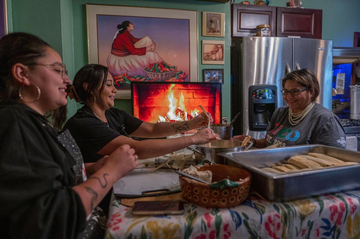 Angelica Vincent, left, Elaina Ramirez and Victoria Rojas prepare tamales at home on Dec. 8 in Kansas City.