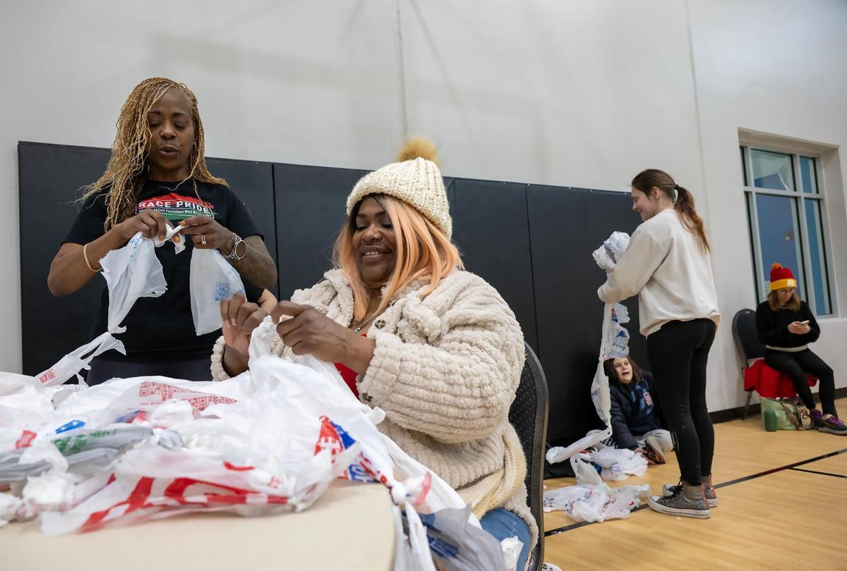 Volunteer Anissa Anthony, left, and Candace Ross tie plastic bags together as part of a project to make plarn mats, sleeping mats made from plastic bags that are crocheted together, during the YMCA MLK Day of Service on Monday, Jan. 20, 2025, at the Cleaver Family YMCA in Kansas City. It takes about 600 bags to create a plarn mat, which will be donated to the unhoused or others in need.