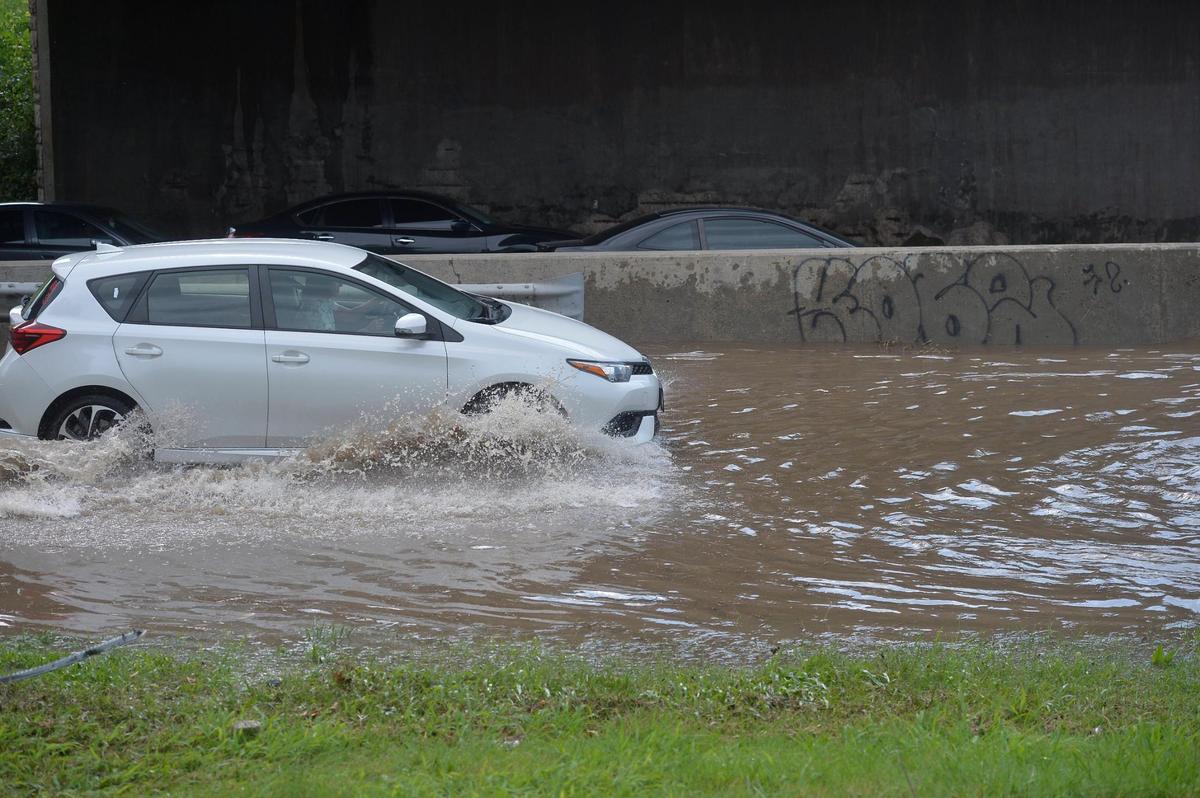 Cars splash through floodwater on the Southwest Trafficway on ramp to northbound Interstate 35 heading toward downtown Kansas City, Wednesday after heavy rains flooded the area. The interstate was impassible for a while due to water pooling in the lanes.