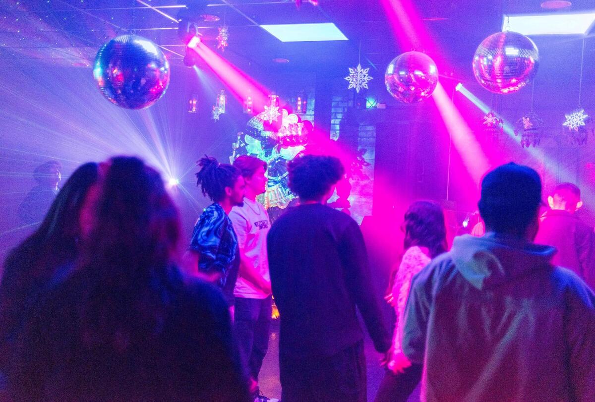 Club goers crowd the dance floor as FK Menace provides music from the DJ booth during a performance at Kali Sound Room.