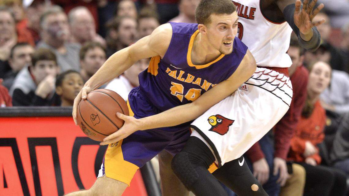 Albany guard Joe Cremo (24) attempts to drive past Louisville forward Deng Adel (22) during the second half of an NCAA college basketball game Wednesday, Dec. 20, 2017, in Louisville, Ky. Louisville won 70-68.