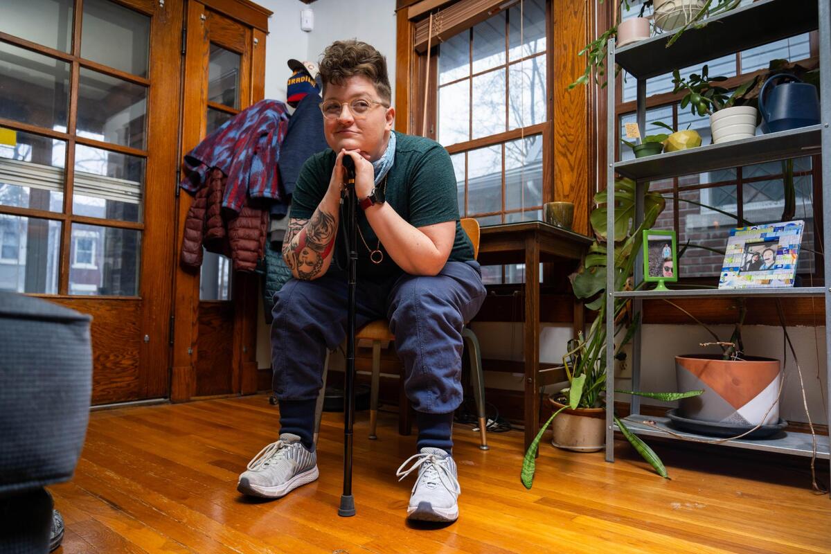One of the complications that surfaced after Jen Benkert-Goche contracted long COVID was that their arches fell in their feet. Due to this, they must wear special shoes and insoles and walk with a cane when outside their home.