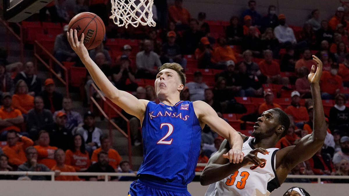 Kansas guard Christian Braun (2) shoots in front of Oklahoma State forward Moussa Cisse (33) in the second half of an NCAA college basketball game Tuesday, Jan. 4, 2022, in Stillwater, Okla. (AP Photo/Sue Ogrocki)