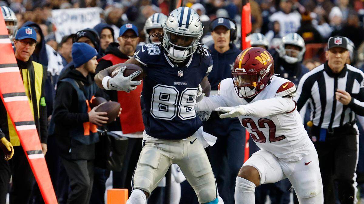 Dallas Cowboys wide receiver CeeDee Lamb (88) is pushed out of bounds after making a catch by Washington Commanders safety Terrell Burgess (32) during the first quarter at FedExField.