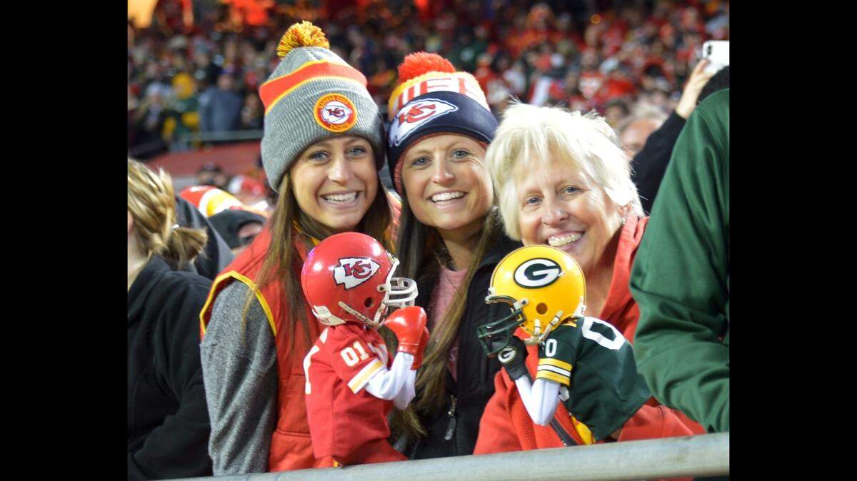 Janel Carbajo posts for a picture with her two daughters and her two puppets during a Chiefs game.