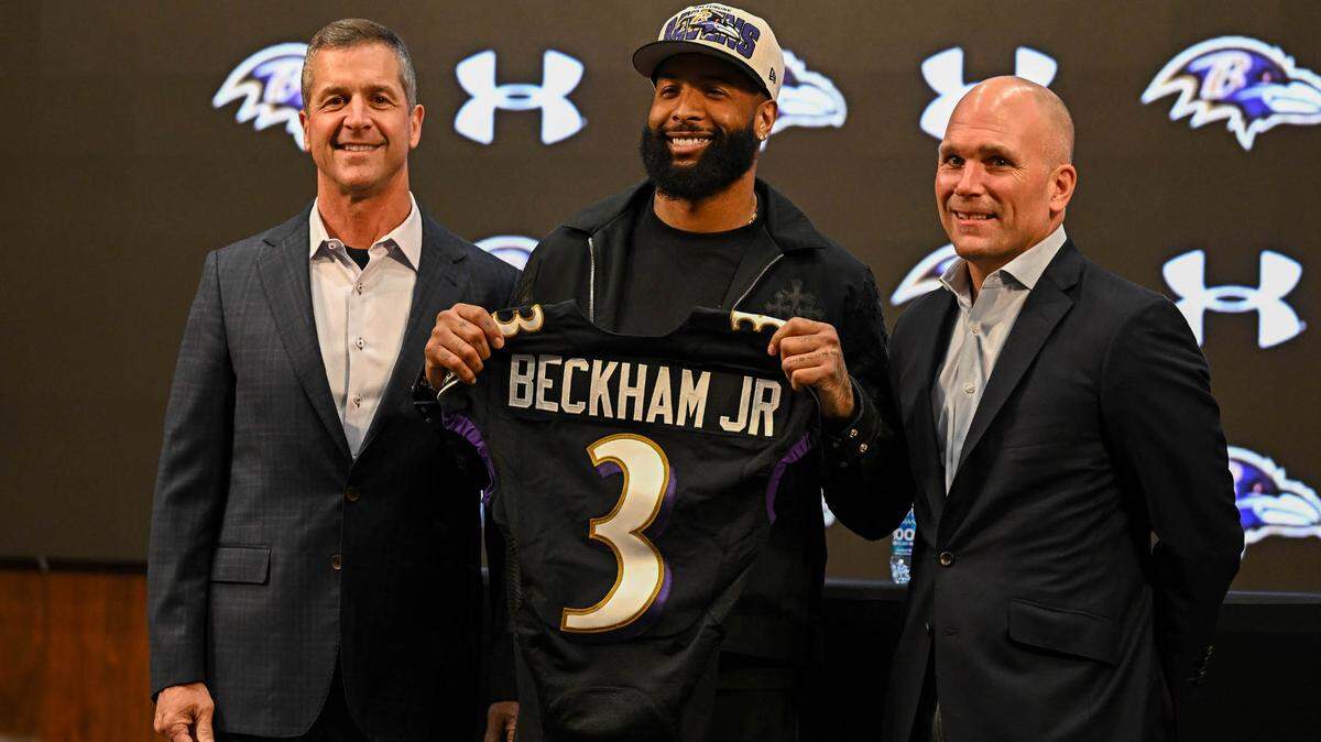 Baltimore Ravens wide receiver Odell Beckham Jr. (middle), head coach John Harbaugh (left), and executive vice president & general manager Eric DeCosta (right) pose with his jersey at his introduction press conference at Under Armour Performance Center.