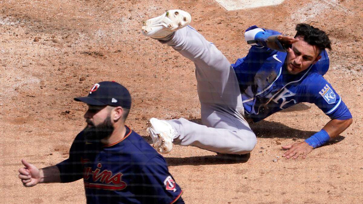 Kansas City Royals’ Nicky Lopez topples in the dirt after scoring on one of two errors against the Minnesota Twins in the fourth inning of a baseball game, Saturday, May 1, 2021, in Minneapolis. At left is Twins pitcher Matt Shoemaker. (AP Photo/Jim Mone)