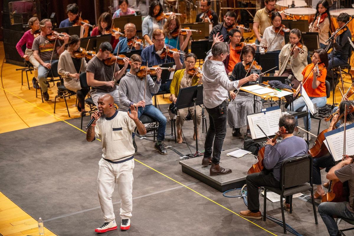 Tech N9ne rehearses in front of the Kansas City Symphony while Tim Davies directs during a practice at the Kauffman Center for the Performing Arts.