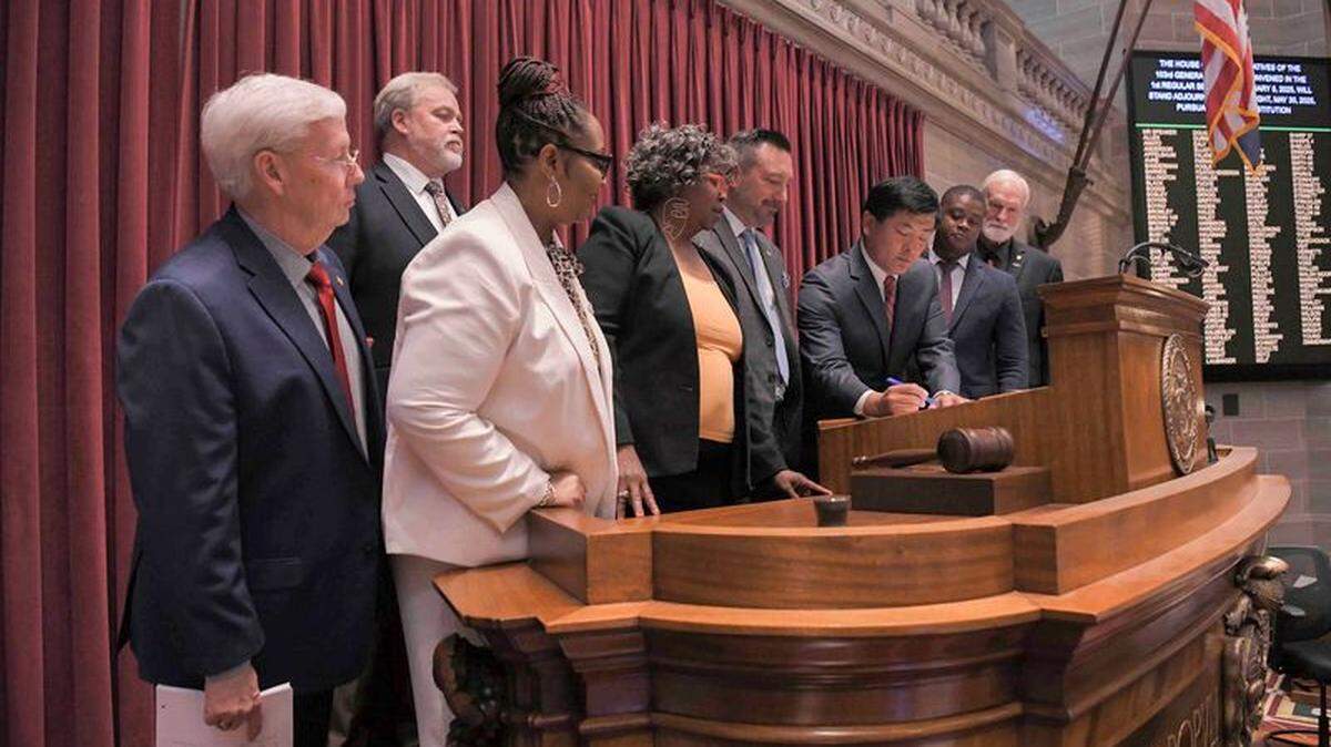 Missouri. Rep. Mike Steinmeyer, left, and other state lawmakers look on as House Speaker Jonathan Patterson signs legislation to close out the 2025 legislative session.