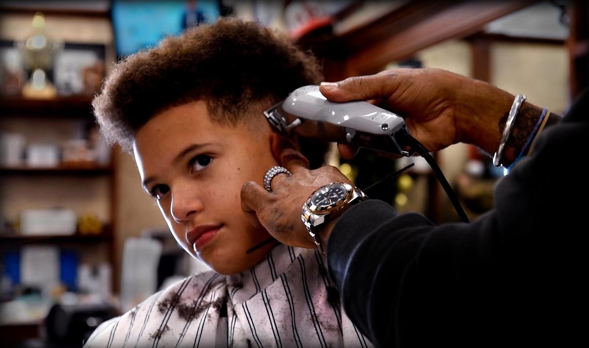 DeJuan Bonds, who is Patrick Mahomes’ barber, works on the hair of 9-year-old T.J. Releford of Kansas City, whose father, Travis Releford, played basketball for the University of Kansas. One of Releford’s KU jerseys hangs on the barbershop wall, as does one of Mahomes’ jerseys.