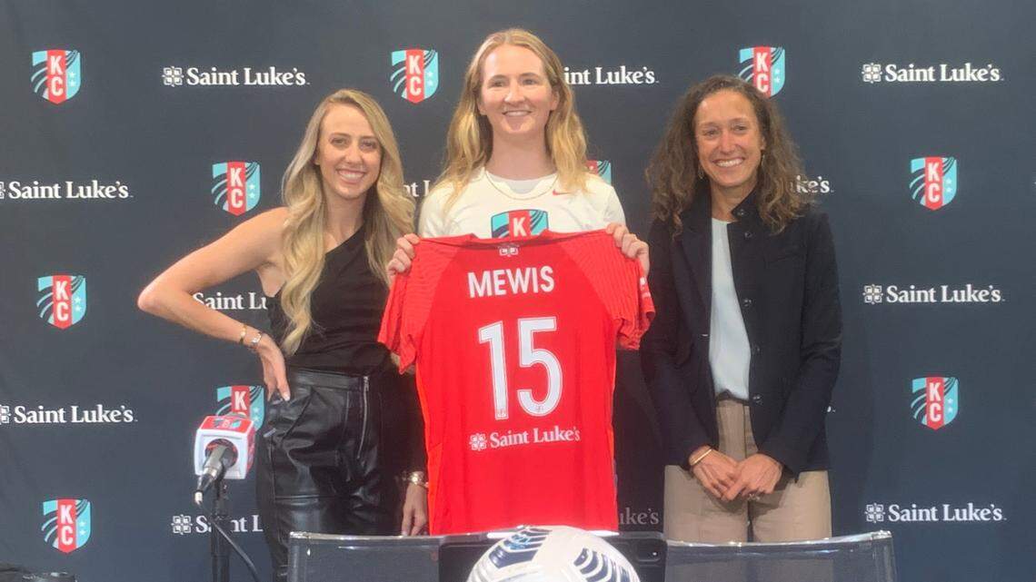 Flanked by co-owners Brittany Matthews, left, and Angie Long, right, newly acquired soccer superstar Sam Mewis shows off her Kansas City Current jersey during Friday’s get-acquainted session in KC.