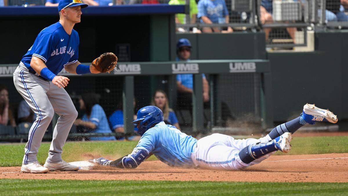 Kansas City Royals’ Salvador Perez dives safely into third base for a triple in front of Toronto Blue Jays third baseman Matt Chapman, left, during the sixth inning of a baseball game, Wednesday, June 8, 2022, in Kansas City, Mo. (AP Photo/Reed Hoffmann)