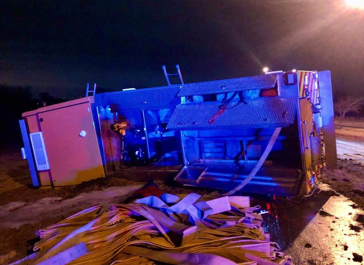 This Lee’s Summit Fire Department pumper rolled onto its side Friday morning after it slipped on icy road conditions.