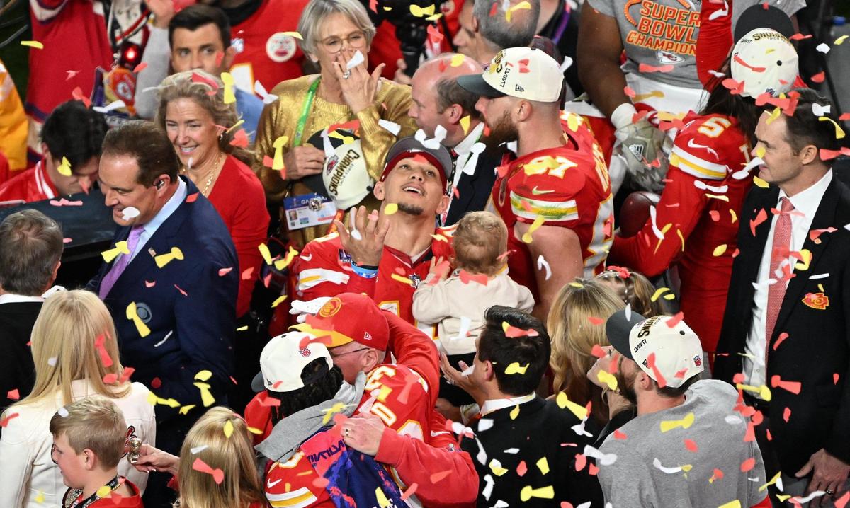Kansas City Chiefs quarterback Patrick Mahomes (15) looks up at the falling graffiti while he holds his son Bronze on the post game championship stage after the Chiefs defeated the San Francisco 49ers 25-22 in Super Bowl LVIII, Sunday, Feb. 11, 2024, in Las Vegas.