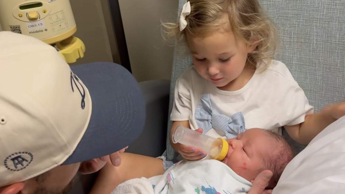 Royals pitcher Michael Wacha helps his first-born, Marcia, feed her new baby brother, Thomas “Tommy” Joseph Wacha.