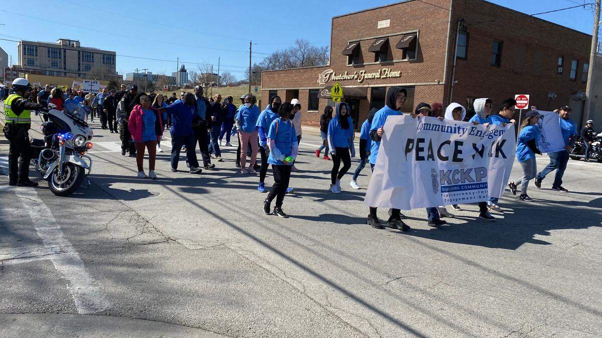 About 200 residents, members of the police department and elected officials in Kansas City, Kansas, participate in a community walk for peace on Saturday, March 26, 2022.