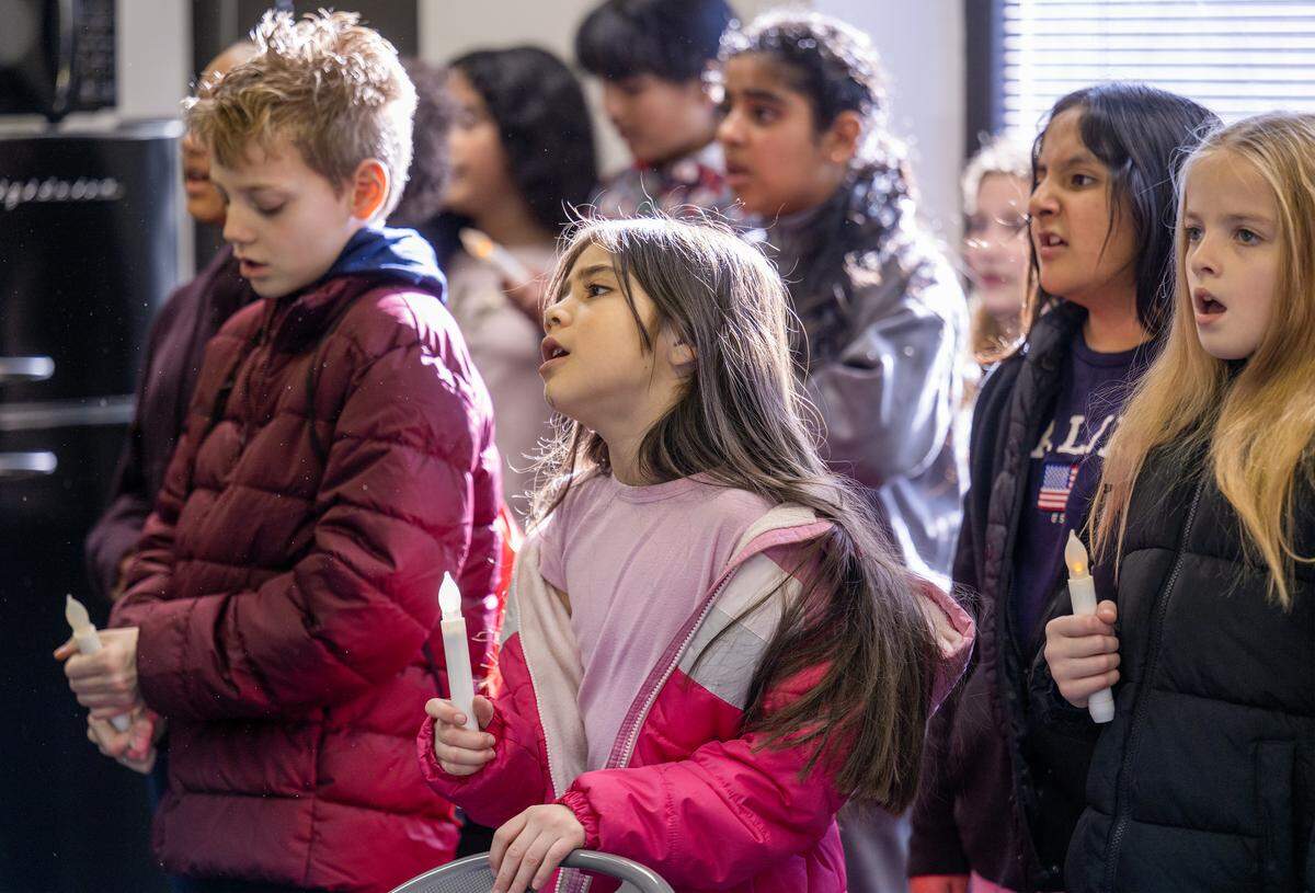 Under the direction of Central Elementary School music teacher Rachel Marlow, special chorus students including fourth grader Zoe Mateo, center, 4th grade, sang “Shine a Light for Peace” at Trinity Fellowship Church on Wedneday, Dec. 17, 2025, in Olathe. The chorus visited four local businesses to spread holiday cheer. 