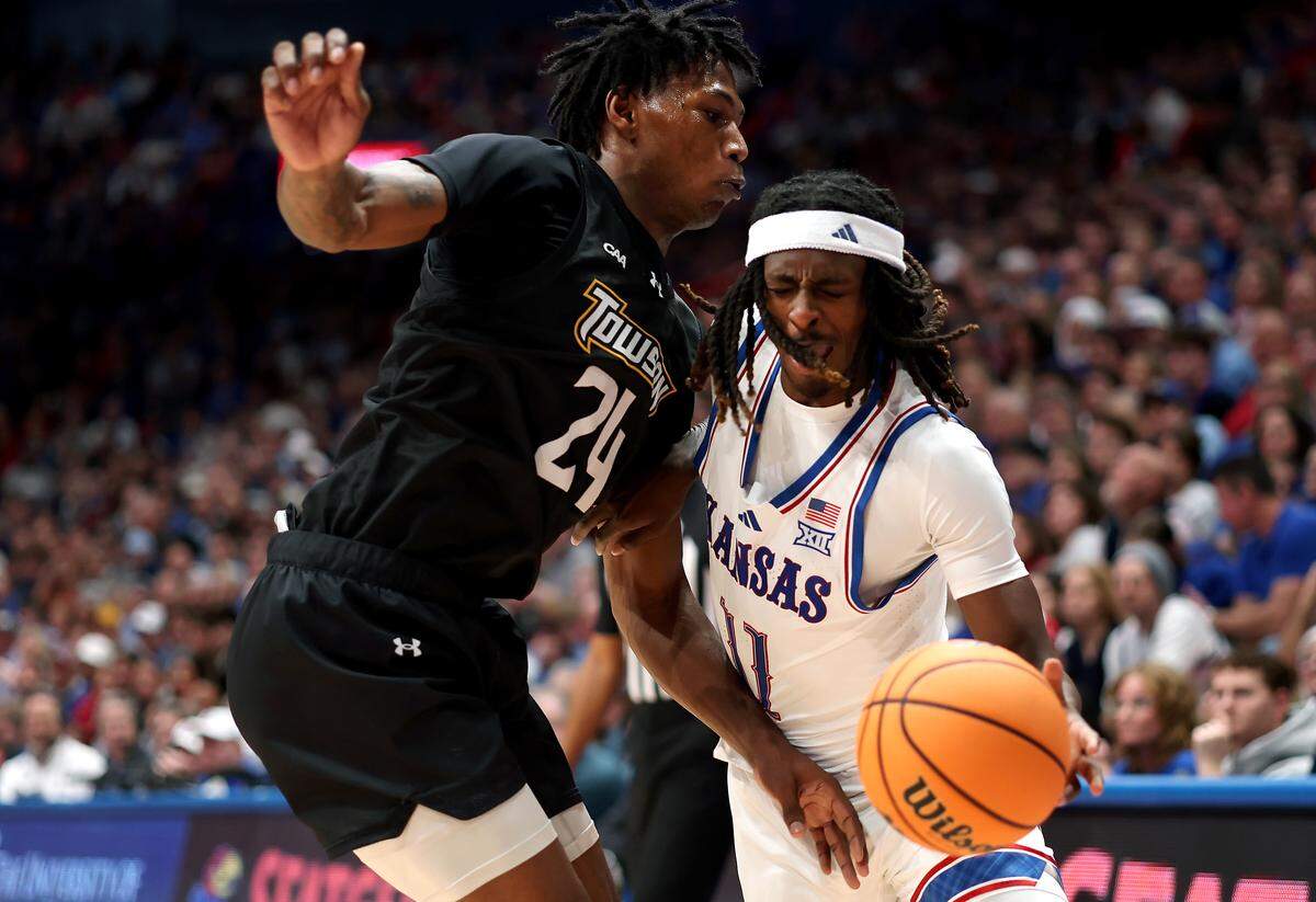 Jamari McDowell #11 of the Kansas Jayhawks drives with the ball as Jaquan Womack #24 of the Towson Tigers defends during the game at Allen Fieldhouse on December 16, 2025 in Lawrence.