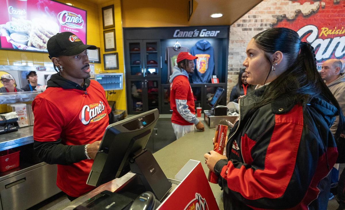 Kansas City Chiefs receiver Mecole Hardman Jr. takes the order of a fan while working the counter at a Raising Cane’s restaurant in Blue Springs on Tuesday. Hardman was joined by teammate L’Jarius Sneed at the event.