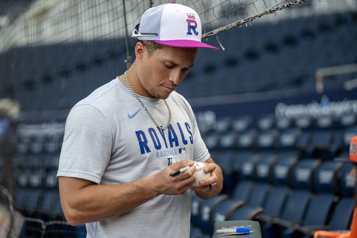 Kansas City Royals left fielder Isaac Collins (1) signs baseballs during batting practice before a game against the Houston Astros on Friday, June 12, 2026, at Kauffman Stadium in Kansas City.