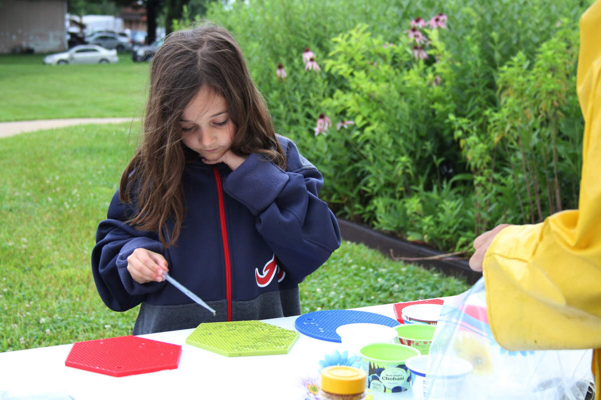At the Pollinator Prairie in Olathe last year, Caylee Jarvis, 6, tried an activity that simulates how bees deposit nectar.