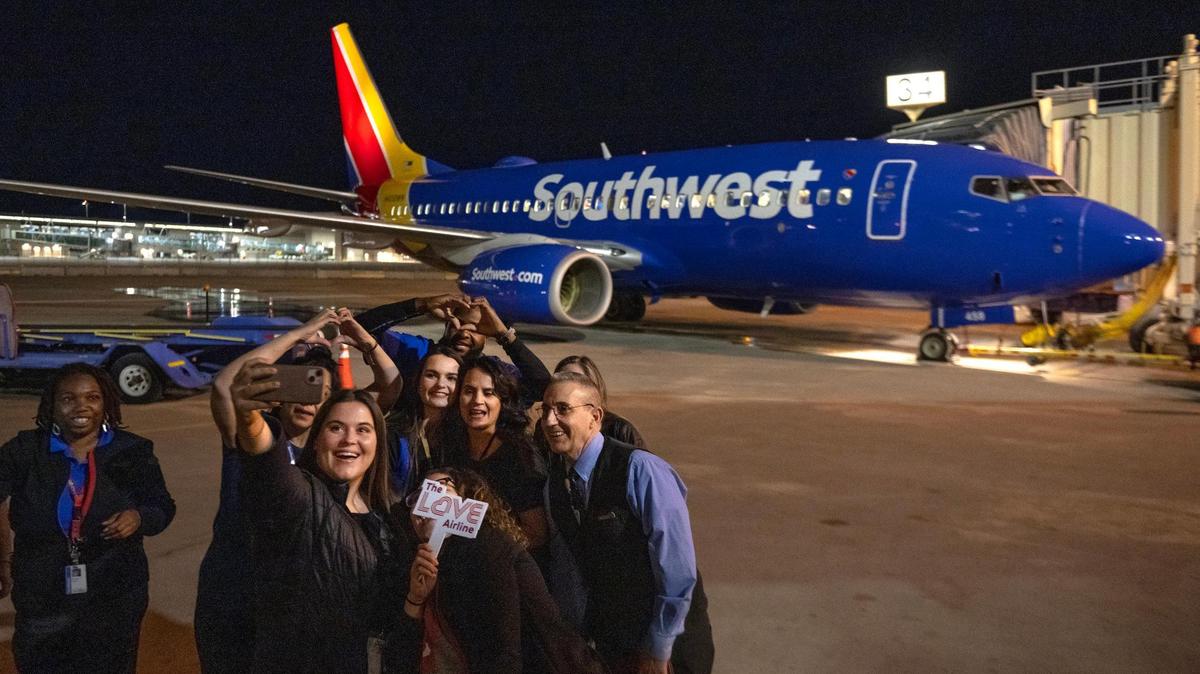 Southwest Airlines employees take a selfie with the final flight to take off from Kansas City International Airport’s old terminals on Monday, Feb. 27, 2023, in Kansas City.