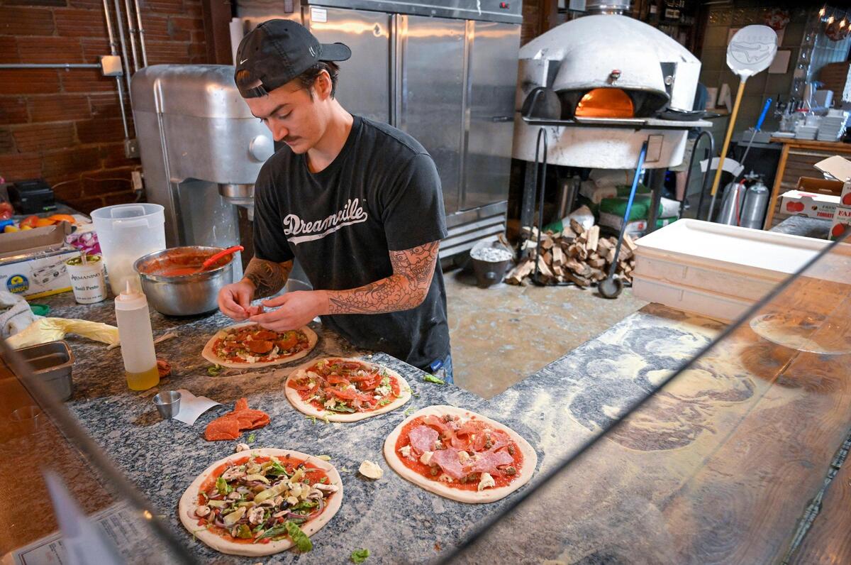 Tyler Soethout, Il Lazzarone’s general manager, prepares pizzas for the 1,000-degree wood-fired oven. They bake in there for about a minute.