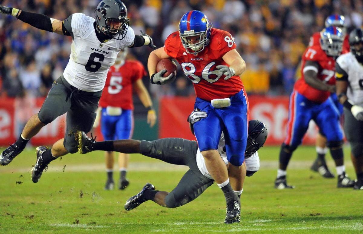 Kansas Jayhawks tight end Tim Biere (86) makes a catch and runs for yardage as Missouri Tigers defensive back Kevin Rutland (20) dives for a tackle in the third quarter at Arrowhead Stadium on Nov. 28, 2009.