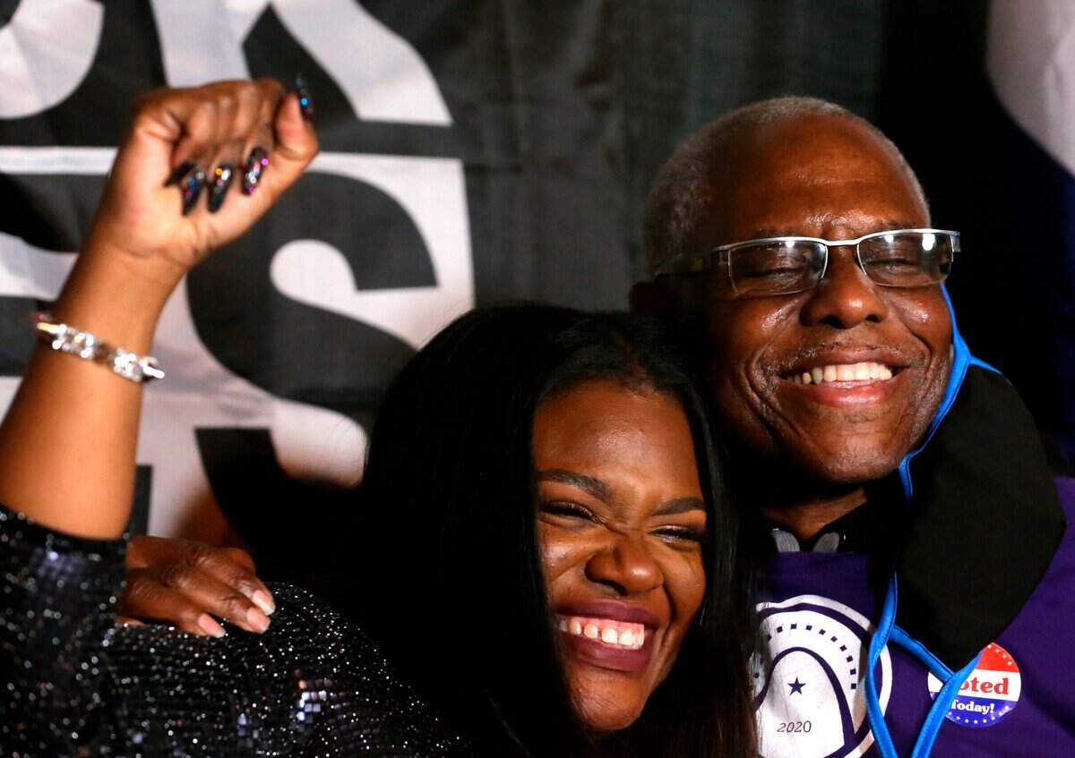 Cori Bush celebrates winning Missouri’s 1st District with her father, Earl Bush, on Tuesday at her election party outside her campaign headquarters in St. Louis. Bush, a nurse and activist, makes history as the first Black woman to represent Missouri in Congress.