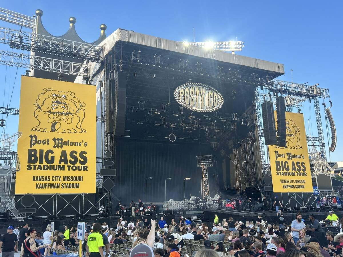 Post Malone’s stage was set up like a small rural highway on Wednesday night at Kauffman Stadium for his Kansas City leg of The Big Ass Stadium Tour Part 2. Props included streetlamps, garbage cans set ablaze and a rickety-looking stadium light that served as a strobe for the concert.