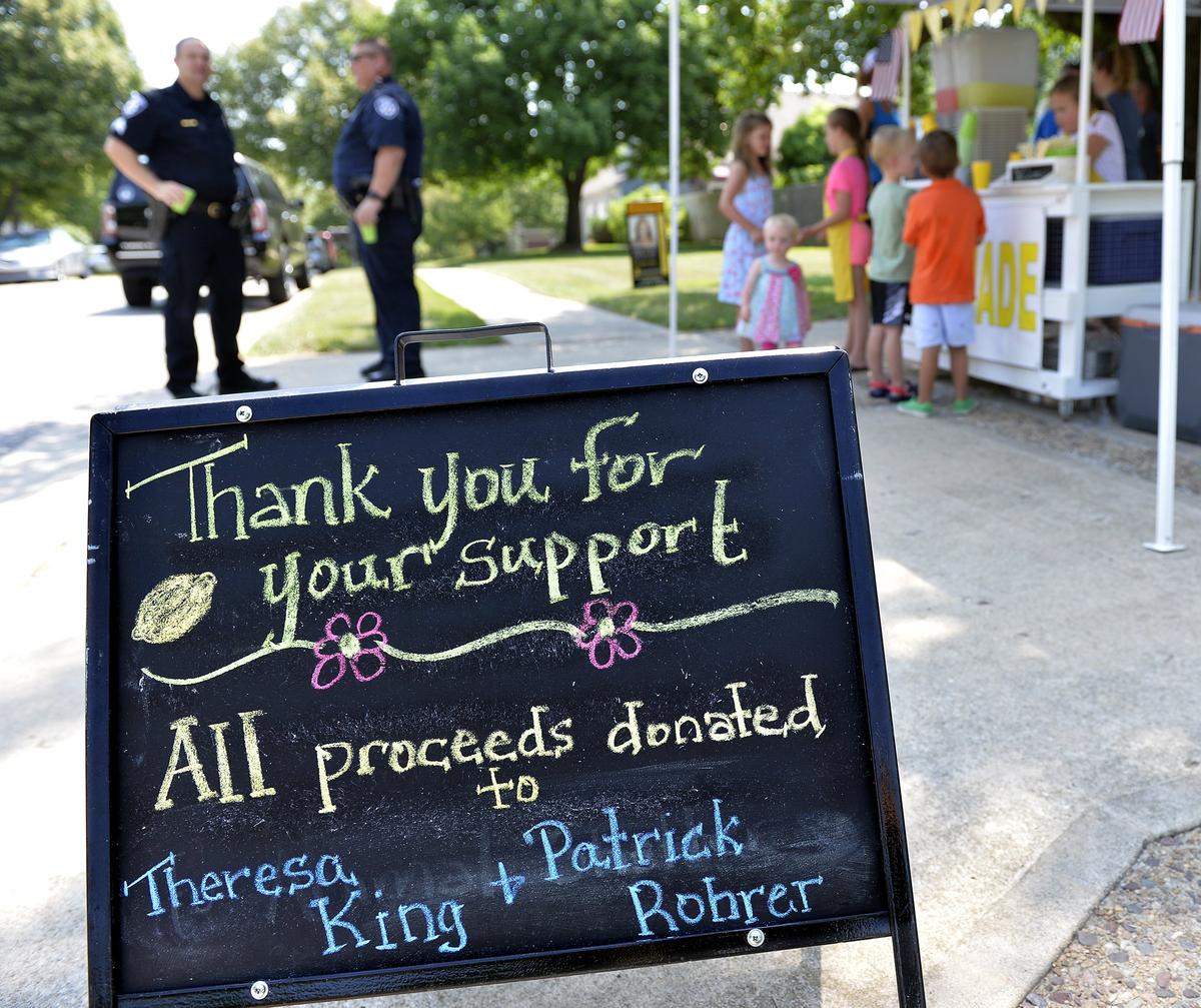 Sisters Kaitlin and Laurin Stotts sold lemonade in their Leawood neighborhood Friday to raise money for the families of slain Wyandotte County Sheriff's deputies Patrick Rohrer and Theresa King.