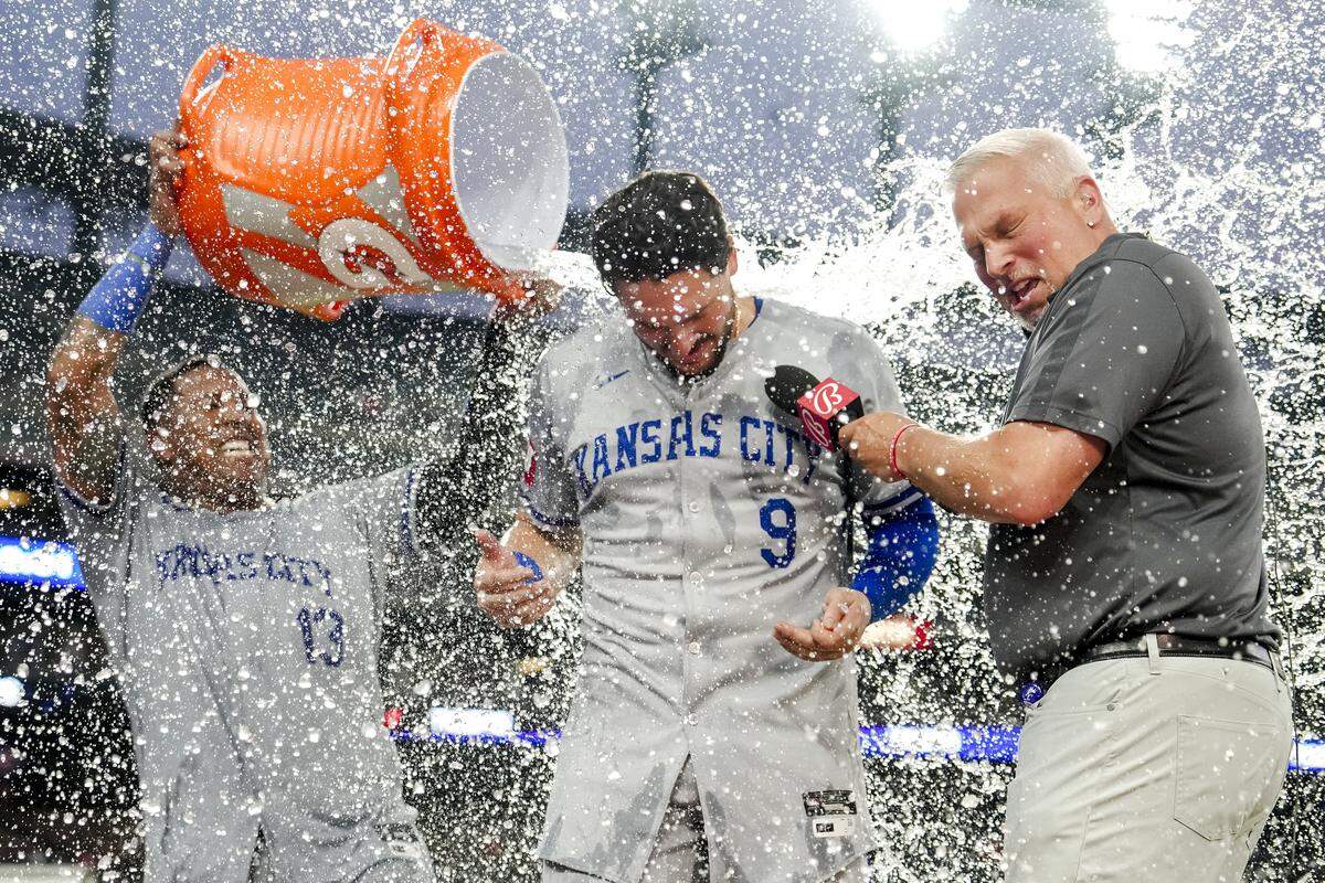 Salvador Perez #13 of the Kansas City Royals pours Gatorade on teammate Vinnie Pasquantino #9 while Pasquantino was being interviewed after their win against the Detroit Tigers at Comerica Park on August 1, 2024 in Detroit.