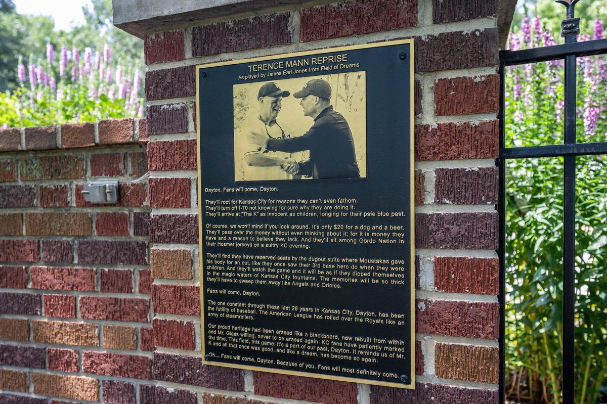 A plaque titled “Terence Mann Reprise” is seen on a brick wall at George P. Toma Field on Monday, June 23, 2025, in Kansas City. The plaque features a tribute to longtime Royals executive Dayton Moore, referencing the film Field of Dreams.