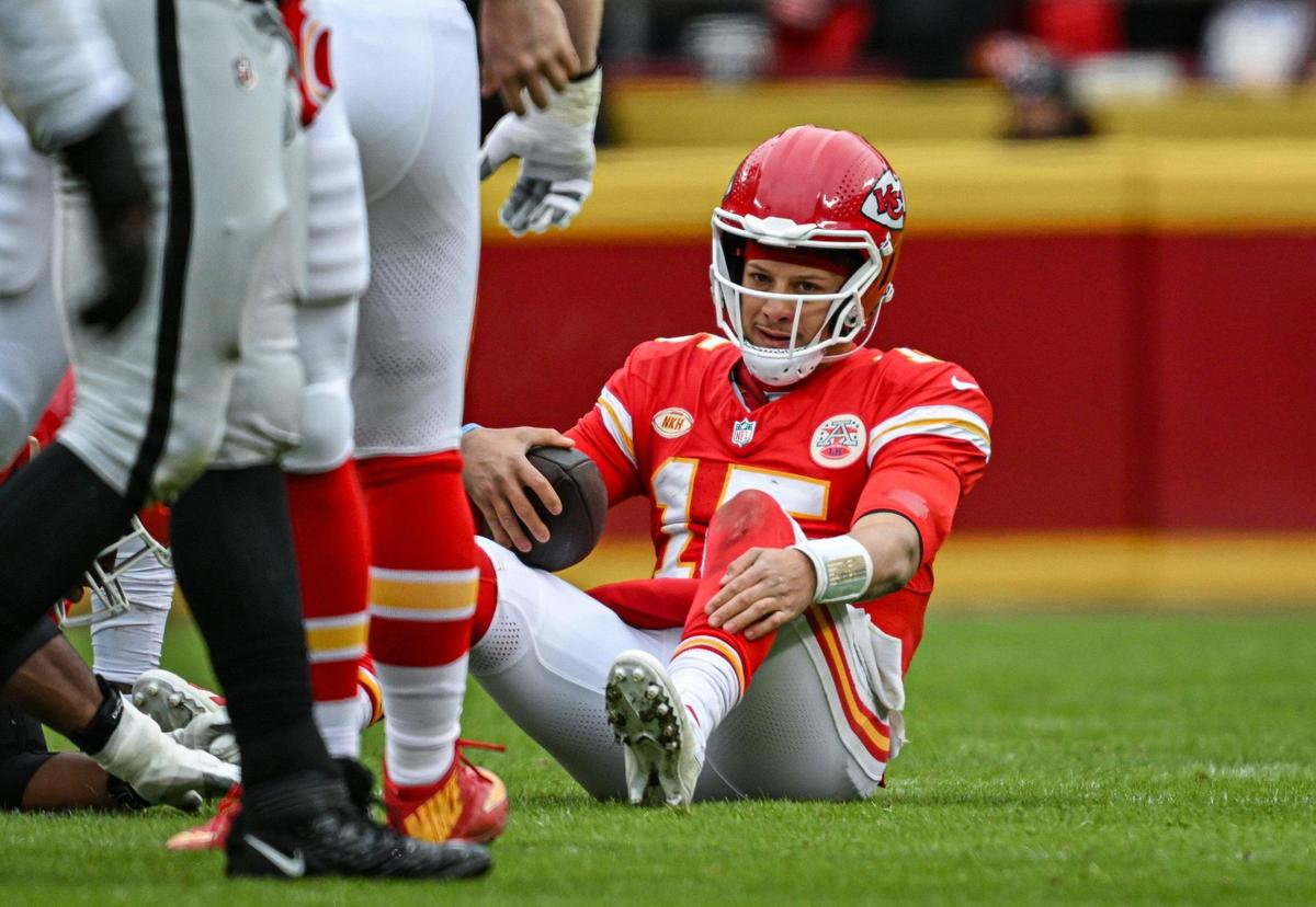 Kansas City Chiefs quarterback Patrick Mahomes (15) sits on the ground after being sacked by the Las Vegas Raiders defense in the first quarter Monday, Dec. 25, 2023, at GEHA Field at Arrowhead Stadium.