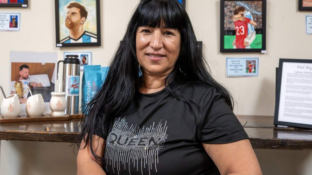 Natalia Testa, an artist visiting from Buenos Aires, Argentina, poses for a portrait in front of her FIFA World Cup-themed artwork at the Crossroads location of Café Corazón on Wednesday, June 24, 2026, in Kansas City.