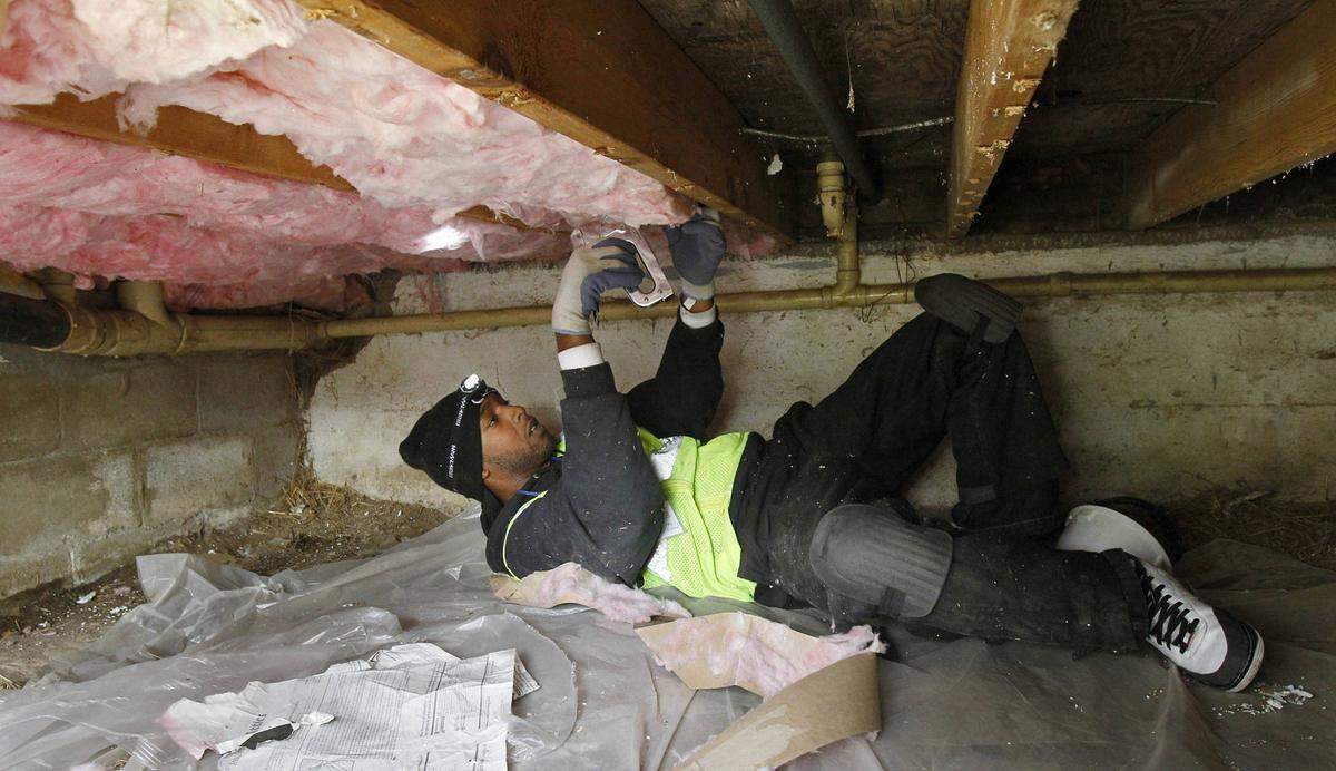 Installing insulation in a crawl space under a house on the East Side in 2011 was funded with money from the Green Impact Zone initiative.