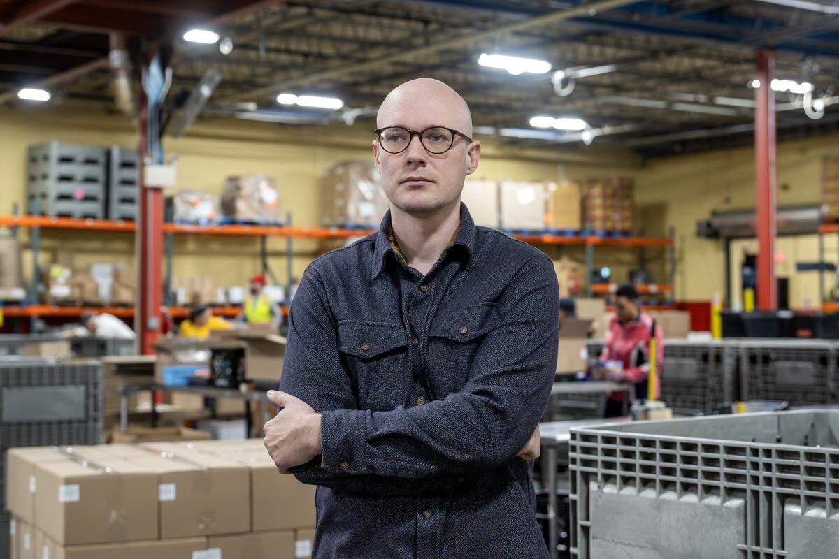 Matt Hamer, communications manager at Harvesters, stands for a portrait by the distribution area of the organization’s warehouse on Tuesday, Oct. 28, 2025, in Kansas City.