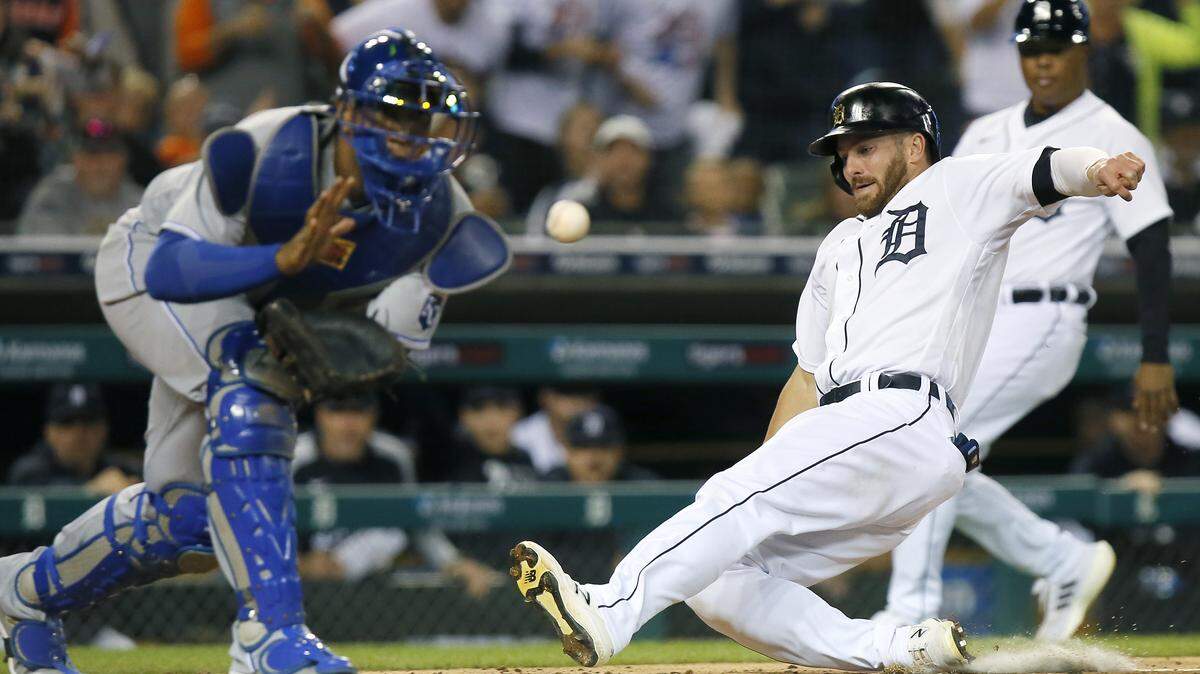 Detroit Tigers’ Robbie Grossman beats the throw to Kansas City Royals’ catcher Salvador Perez, left, to score on a double by Miguel Cabrera during the sixth inning of a baseball game Saturday, Sept. 25, 2021, in Detroit. (AP Photo/Duane Burleson)