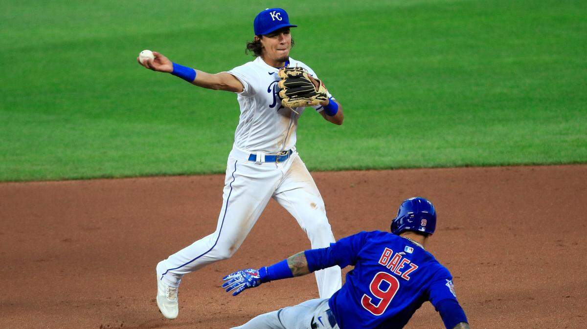 Kansas City Royals second baseman Nicky Lopez (1) turns a double play over the top of Chicago Cubs Javier Baez (9) during the fourth inning of a baseball game at Kauffman Stadium in Kansas City, Mo., Wednesday, Aug. 5, 2020. Chicago Cubs Anthony Rizzo was out at first and a run scored on the play. (AP Photo/Orlin Wagner)