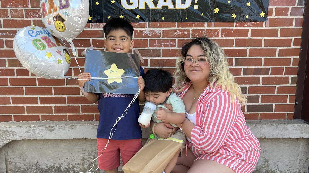 Cynthia Astorga and two of her children gather for a portrait after last year’s fifth grade graduation ceremony at New Stanley.