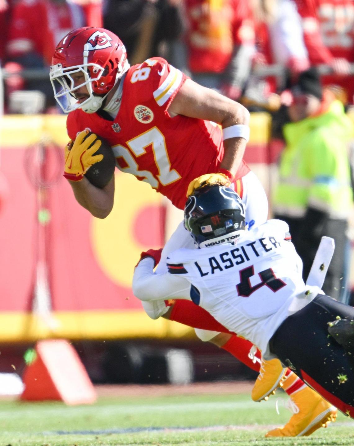 Houston Texans cornerback Kamari Lassiter (4) tackles Kansas City Chiefs tight end Travis Kelce (87) after Kelce made a reception in the first half on Saturday Dec. 21, 2024, at GEHA Field at Arrowhead Stadium.