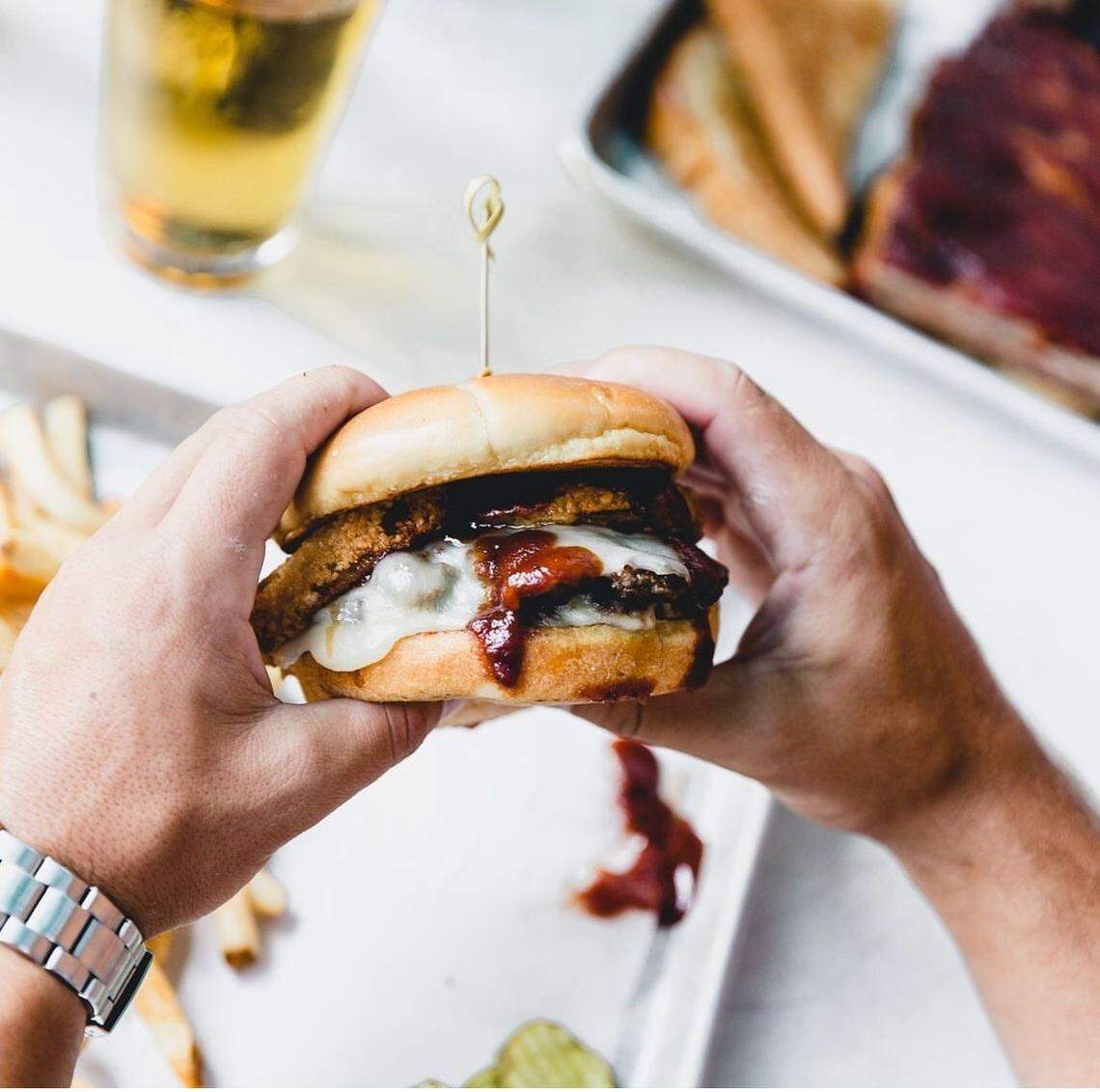 County Road Ice House’s Z-Man Burger has two fresh chuck and smoky brisket blend patties topped with smoked provolone, onion rings, and Joe’s Original BBQ Sauce.