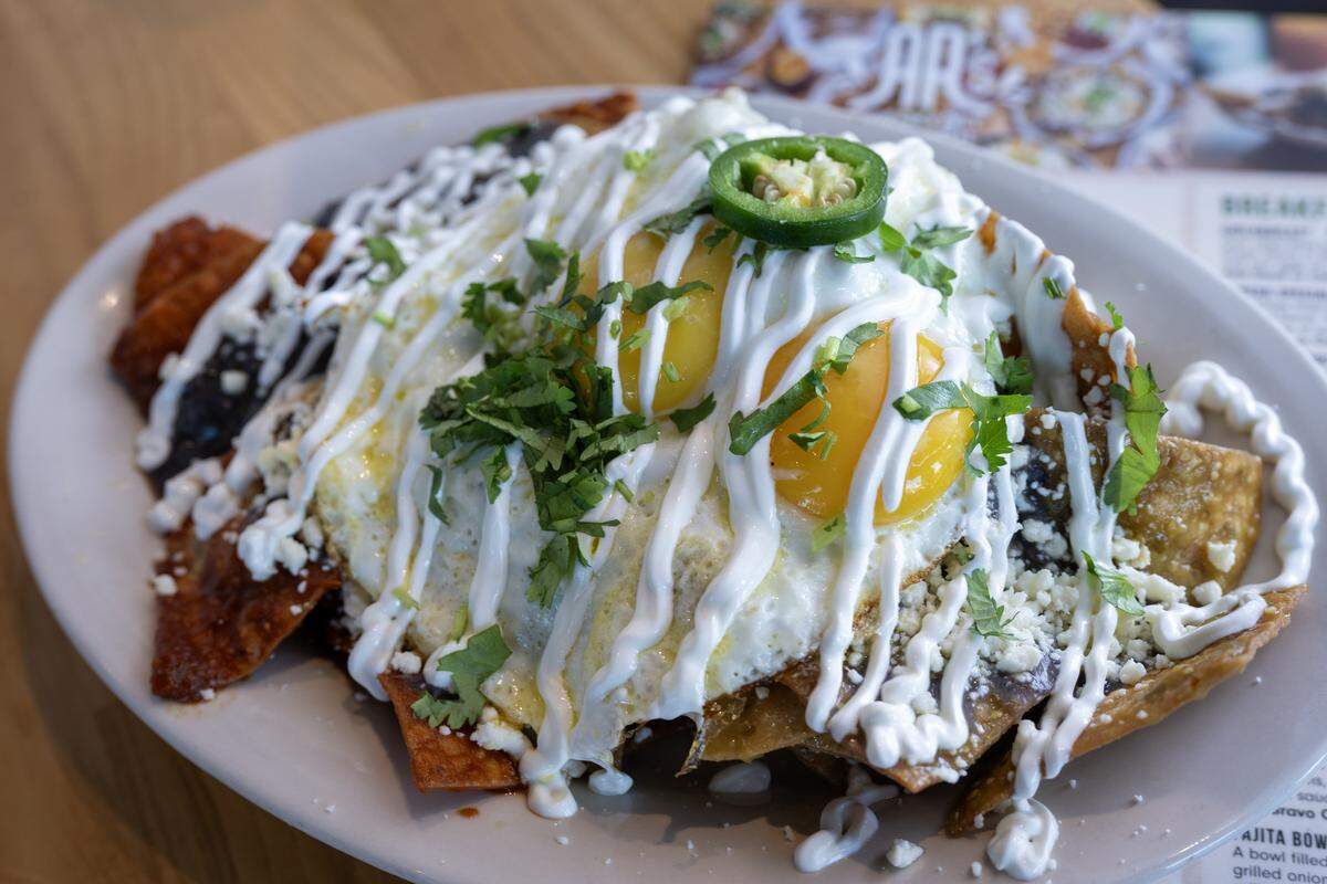 Chilaquiles, corn chips fried and smothered in red or green sauce, opped with sour cream, Queso fresco, and two eggs served with breakfast potatoes and black beans, $13.99 at at AR's Breakfast and Brunch, 8021 Metcalf Ave., in Overland Park.
