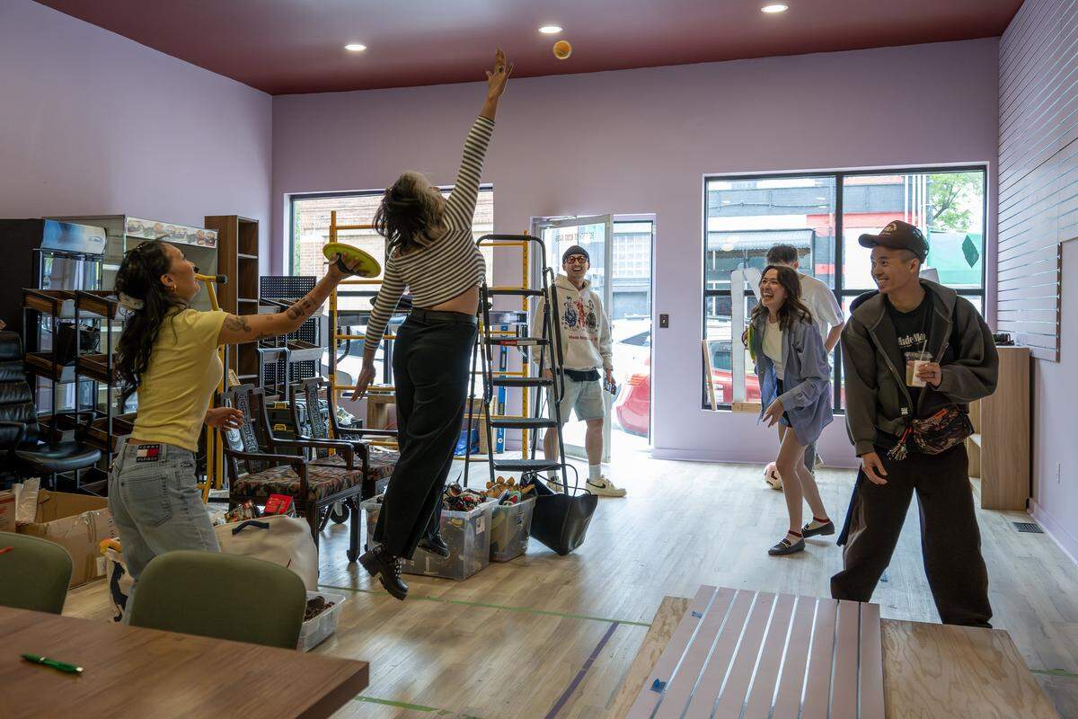 Jackie Nguyen, owner of Cafe Cà Phê, left, plays catch with team members at Hella Good Deeds on Friday, May 8, 2026, in Kansas City.
