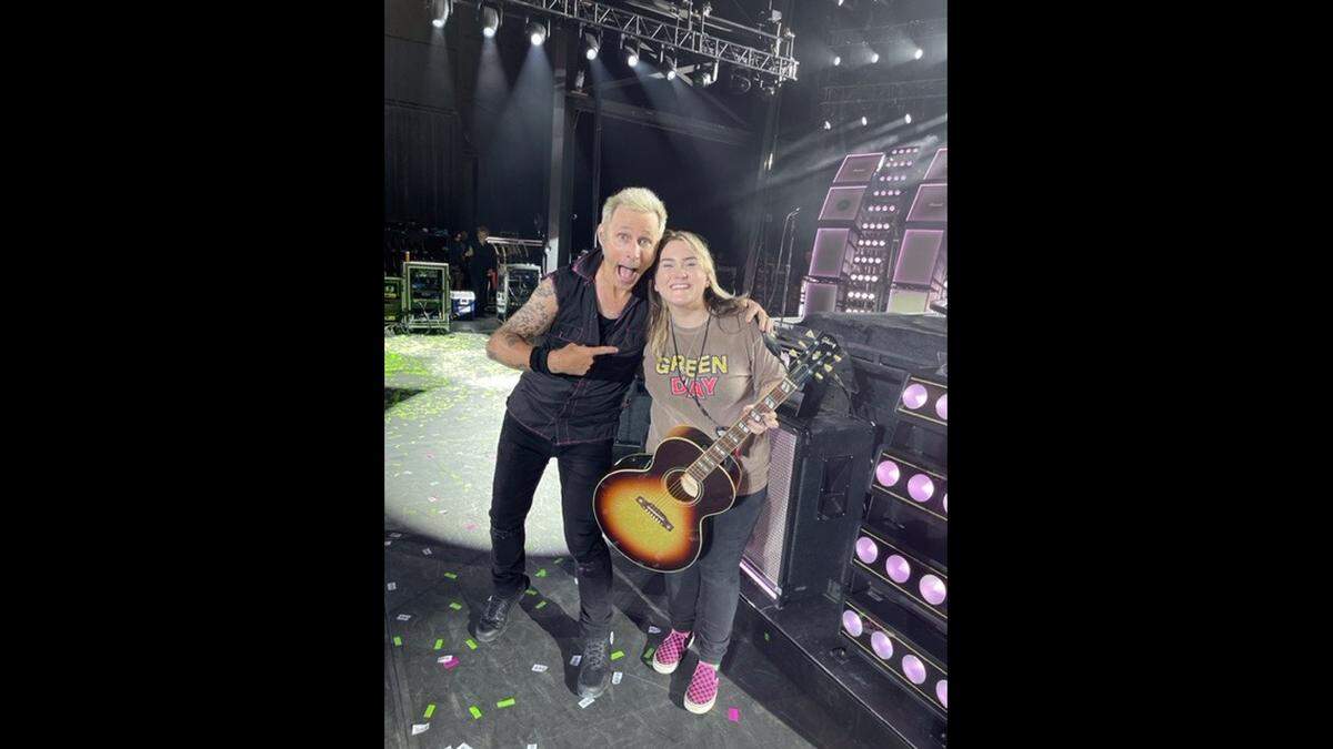 Ruby Leigh, a country singer from Foley, Missouri who was a contestant on NBC’s “The Voice,” took pictures with Green Day band member Mike Dirnt after singing “Good Riddance (Time Of Your Life)” with the band Tuesday.